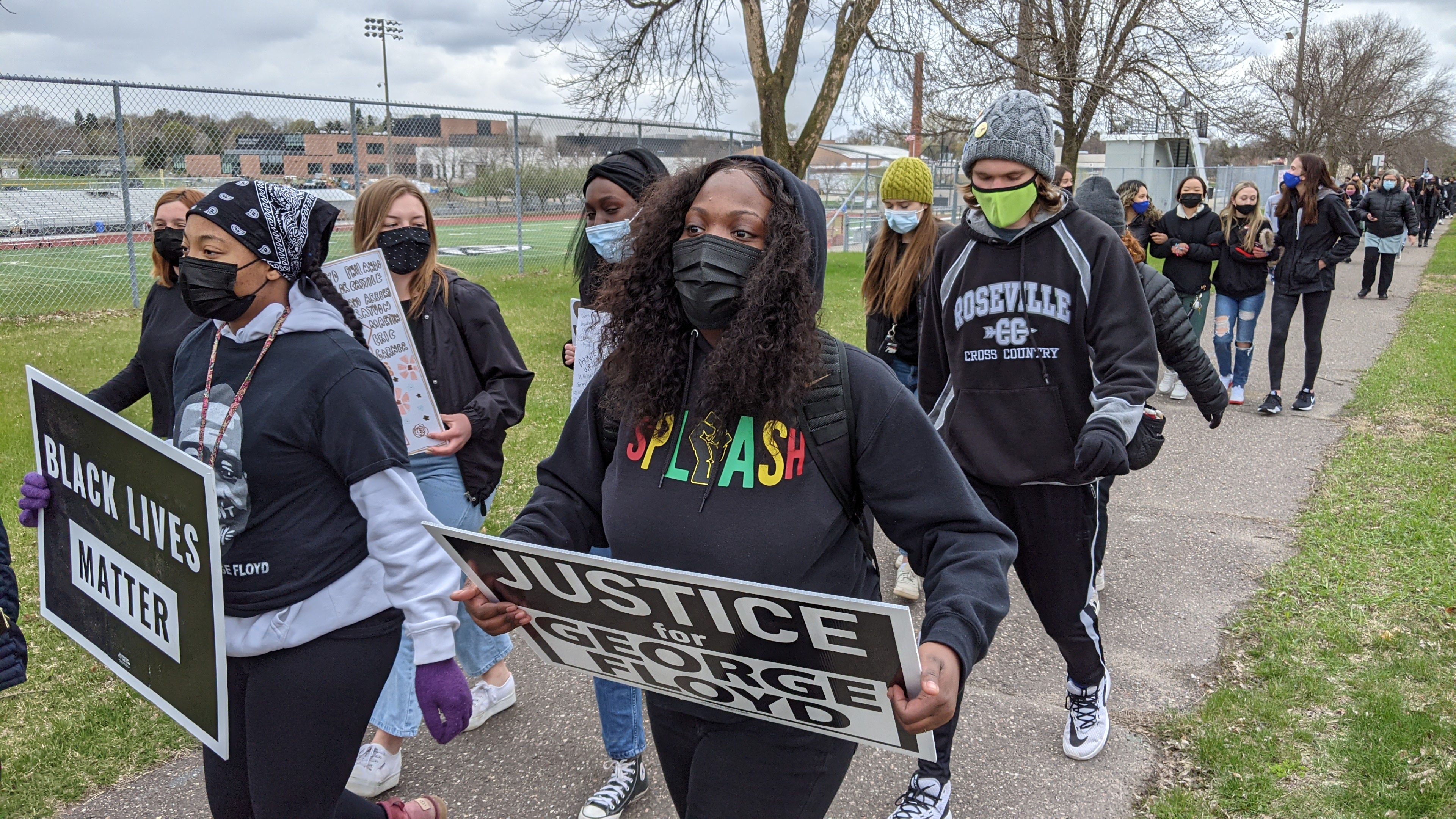 Students with signs on the way to the police station
